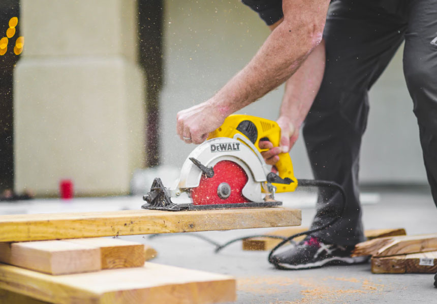 man sawing piece of wood